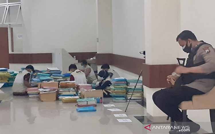Petugas Komisi Pemberantasan Korupsi (KPK) tengah memeriksa dokumen dari kantor Dinas Penanaman Modal, Pelayanan Terpadu Satu Pintu, dan Tenaga Kerja, yang berada di lantai dasar Gedung Balai Kota Among Tani Kota Batu, Kamis (7/1/2021)