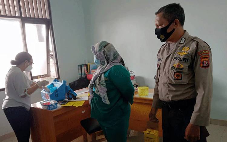 Anggota Polsek Sebangau saat melaksanakan pengamanan vaksinasi Covid-19 jenis Sinovac terhadap tenaga Nakes di Puskesmas Kalampangan.