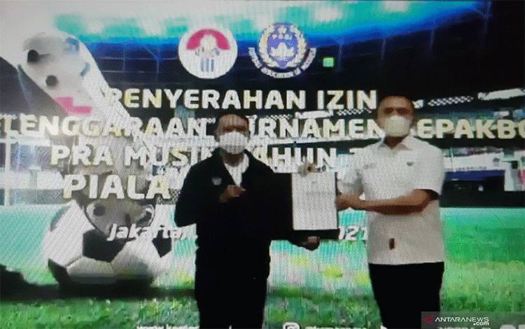 Menteri Pemuda dan Olahraga (Menpora) Zainudin Amali (kiri) menyerahkan izin keramaian dari Polri untuk turnamen pramusim Piala Menpora 2021 kepada Ketua Umum PSSI Mochamad Iriawan di Gedung Kemenpora, Jakarta, Jumat (19/2/2021). Sehari sebelumnya, izin tersebut diberikan oleh Kapolri Jenderal Polisi Listyo Sigit Prabowo kepada Menpora di Mabes Polri. (Michael Siahaan)