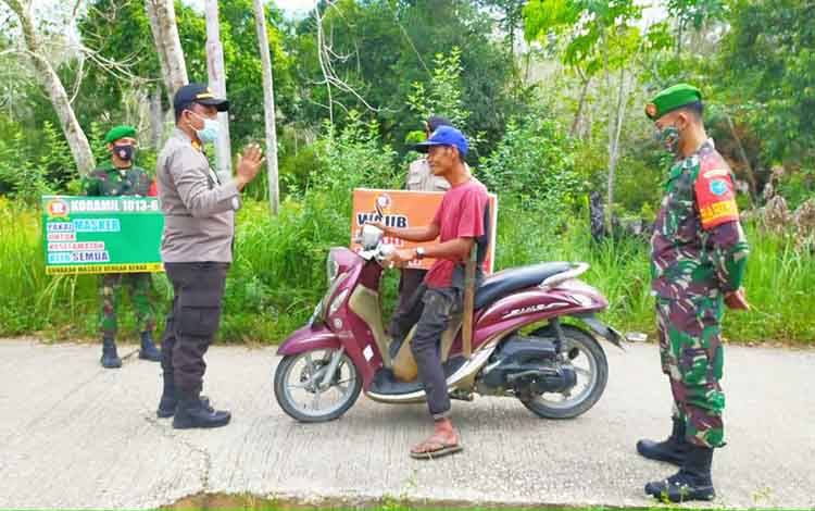 kapolsek Lahei didampingi Danramil Lahei saat memberikan teguran sekaligus sosialisasi akan protokol kesehatan kepada warga dalam program PPKM, Rabu 3 Maret 2021
