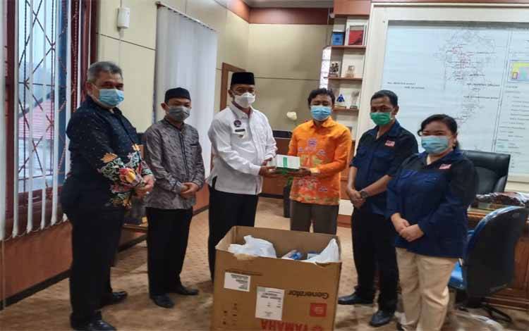 Bupati Sukamara, Windu Subagio menerima hibah thermo gun dari Ketua KPU Sukamara, Ahmad Zen Alantany