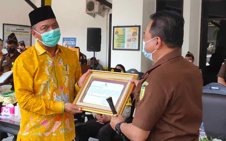 Bupati Sukamara, Windu Subagio menyerahkan testimoni dukungan pencanganan WBK WBBM kepada Kajari Sukamara, Fajar Sukristiawan