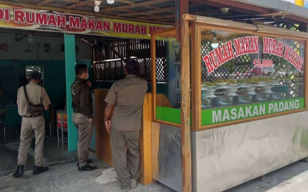Satpol PP Palangka Raya saat memberikan imbauan kepada pemilik warung makan agar memasang tirai.