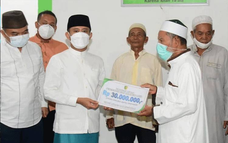 Wali Kota Palangka Raya Fairid Naparin, menyerahkan bantuan saat buka puasa bersama warga.