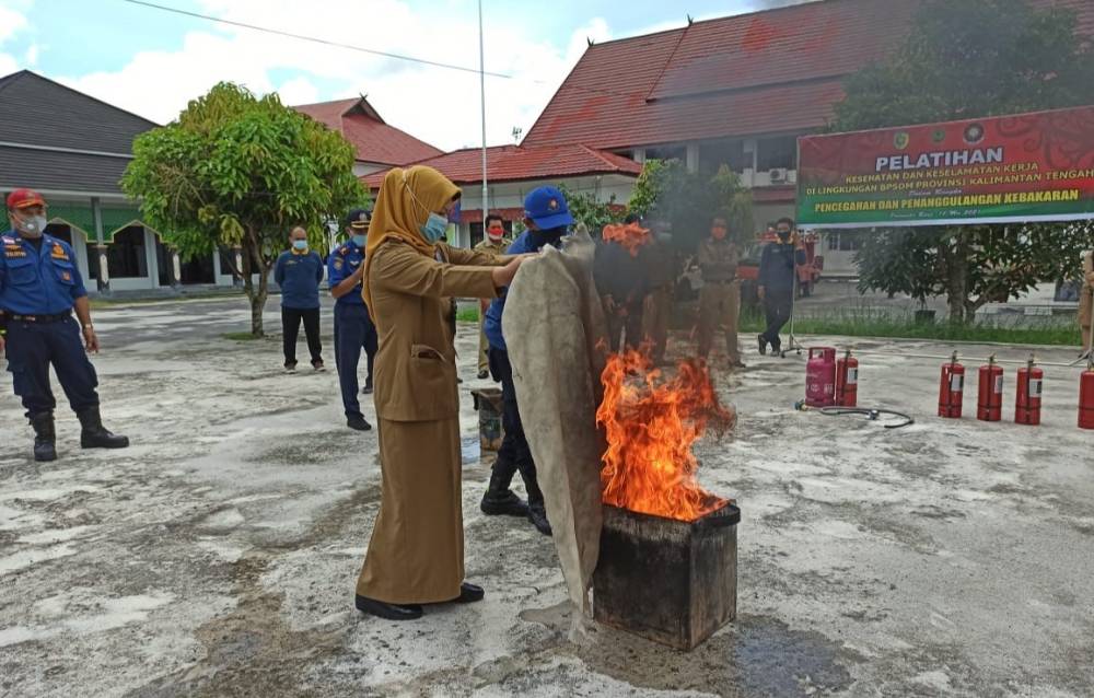 Kepala BPSDM Kalteng Sri Widanarni saat memperagakan cara memadamkan api.