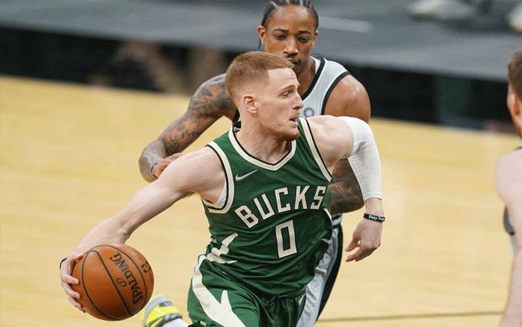 Guard Milwaukee Bucks Donte DiVincenzo (tengah) melewati hadangan forward San Antonio Spurs DeMar DeRozan dalam laga NBA di AT&T Center, San Antonio, Texas, Amerika Serikat, 10 Mei 2021. (REUTERS/USA TODAY Sports/Daniel Dunn)