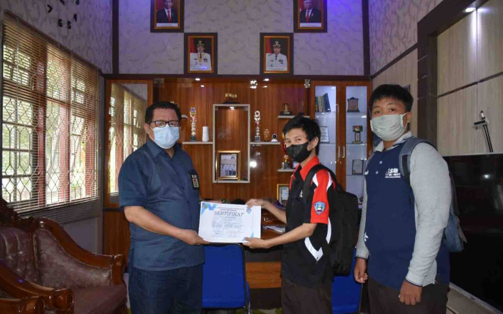 Kepala Diskominfo Kapuas, Junaidi saat menyerahkan sertifikat magang kepada Siswa SMKN 1 Kuala Kapuas pada Jumat, 25 Juni 2021.
