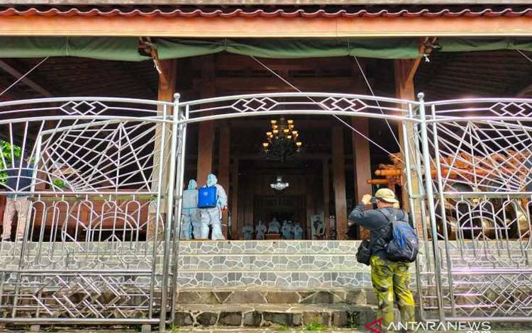 Petugas yang mengenakan alat pelindung diri lengkap mengurus pemakaman dalang terkenal Ki Manteb Soedarsono di rumah duka di Dusun Sekiteran, Kelurahan Doplang, Kecamatan Karangpandan, Kabupaten Karanganyar, Jawa Tengah, Jumat (2/7/2021)