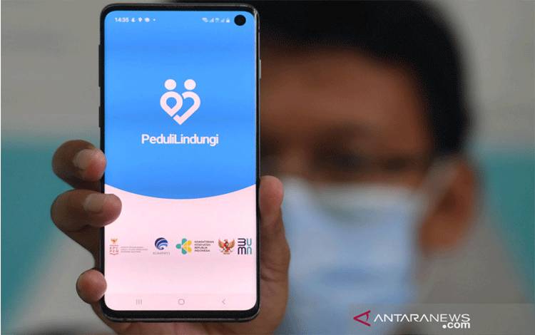 Seorang warga menunjukan aplikasi PeduliLindungi yang telah diinstal pada gawai miliknya di Surabaya, Jawa Timur, Kamis (14/1/2021). Aplikasi buatan Pemerintah Indonesia tersebut digunakan untuk melacak sebaran COVID-19 di Indonesia, juga mengecek dan melakukan registrasi ulang bagi calon penerima vaksin COVID-19. ANTARA FOTO/Zabur Karuru/rwa.