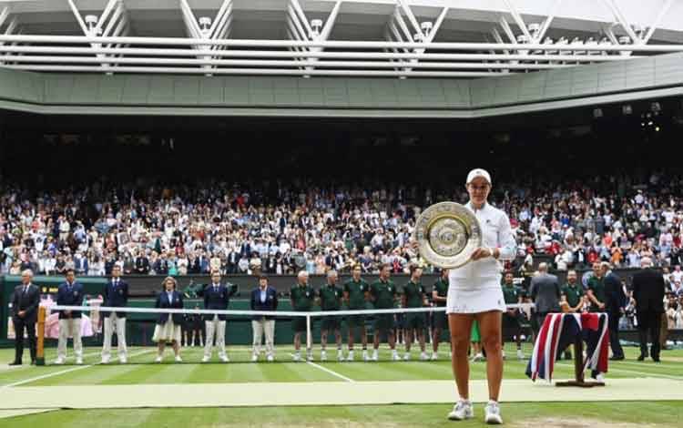 Petenis Australia Ashleigh Barty bersama trofi Wimbledon yang diraihnya setelah mengalahkan petenis Republik Ceko Karolina Pliskova di All England Lawn Tennis and Croquet Club, London, Inggris, 10 Juli 2021. ANTARA/REUTERS/Toby Melville