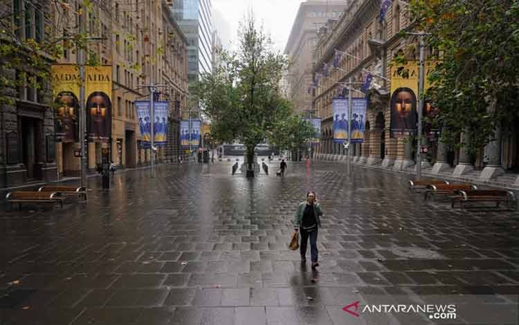 Seorang warga di Sydney, Australia, Rabu (30/6/2021), berjalan di Martin Place, yang tidak biasanya sunyi, di pusat kota saat penguncian diberlakukan untuk membatasi penyebaran penyakit virus corona (COVID-19). (ANTARA FOTO/REUTERS/Loren Elliott/hp/cfo)