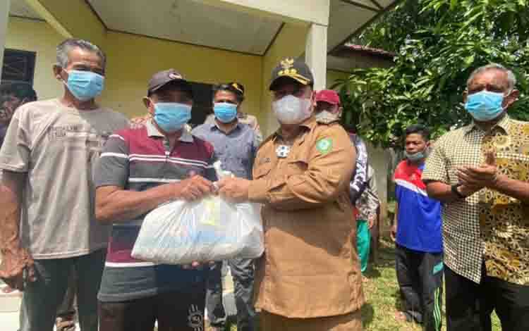 Bupati Kotim Halikinnor saat memberikan bantuan sembako kepada warga.