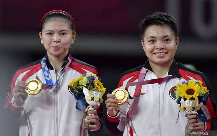 Pebulutangkis ganda Putri Indonesia Greysia Pollii (kiri) dan Apriyani Rahayu memperlihatkan medali emas yang berhasil mereka raih untuk nomor bulutangkis ganda putri Olimpiade Tokyo 2020 di Musashino Forest Sport Plaza, Tokyo, Jepang, Senin (2/8/2021). (ANTARA FOTO/SIGID KURNIAWAN)