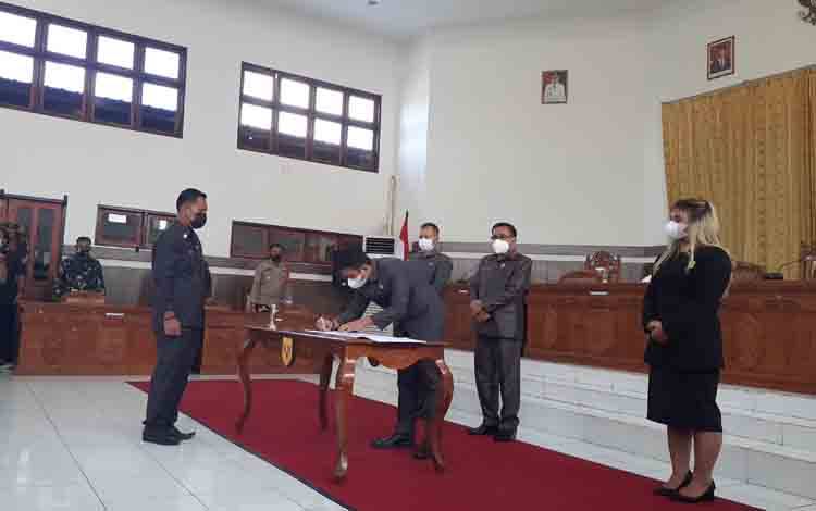 Bupati Gumas, Jaya S Monong bersama Ketua DPRD Akerman Sahidar, Wakil Ketua II Neni Yuliani dan lainnya menyaksikan Wakil Ketua I Binartha menandatangani kesepakatan Raperda Perubahan APBD 2021.