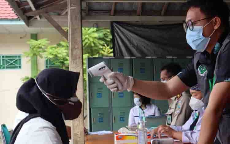 Petugas UPT BKN Palangka Raya sedang memeriksa suhu tubuh salah satu peserta test CPNS