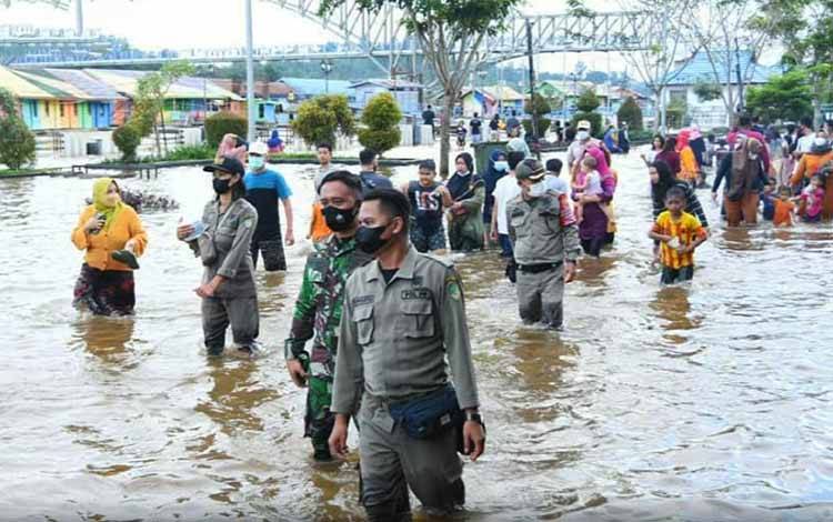 Tim yustisi Barito Utara saat memberikan himbauan kepada warga yang sedang bermain banjir