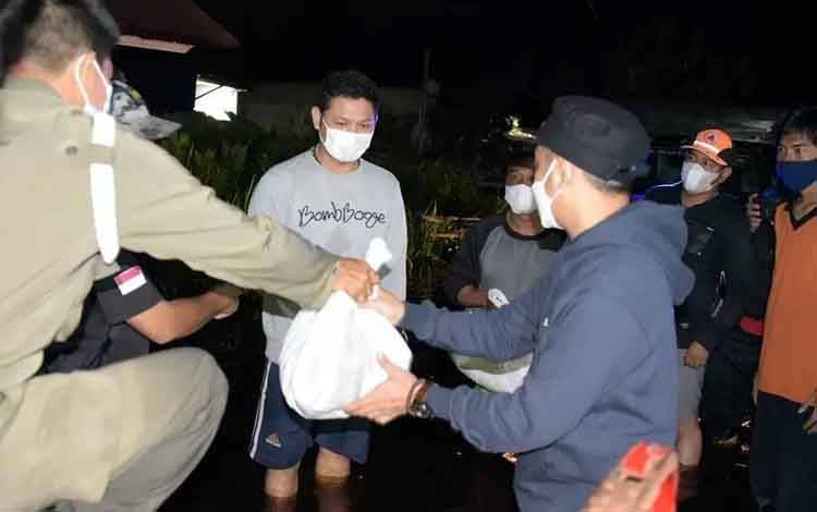Wali Kota Palangka Raya, Fairid Naparin saat menyalurkan bantuan kepada masyarakat terdampak banjir.