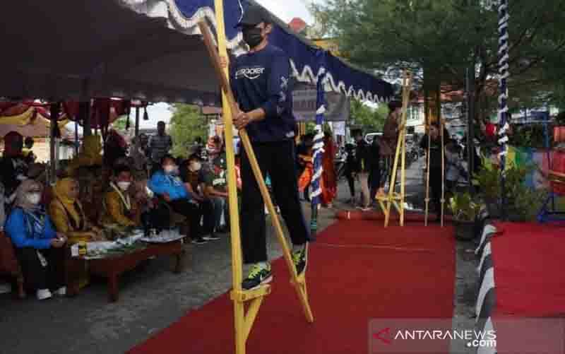 Salah satu warga saat memarkan kemahirannya bermain egrang di kampung bermain tradisi di Antasan Besar di Banjarmasin yang diresmikan Wakil Wali Kota Banjarmasin H Arifin Noor, Minggu (26/9/2021). (foto : ANTARA/Humas Pemkot Banjarmasin)