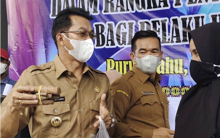 Bupati Murung Raya Perdie M. Yoseph saat berbincang dengan salah satu pedagang yang menerima bantuan modal dari pemerintah.