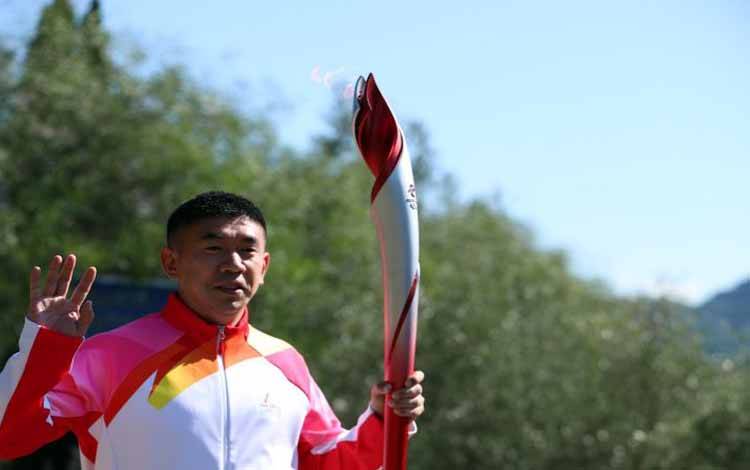 Pembawa obor kedua mantan atlet speed skater China Li Jiajun berlari dengan api Olimpiade saat upacara penyalaan api Olimpiade untuk Olimpiade Musim Dingin Beijing 2022 di Ancient Olympia, Olympia, Yunani, Senin (18/10/2021)