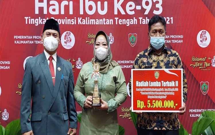 Bupati Kobar, Nurhidayah memegang piala penghargaan juara II Lomba GSI dari Pemprov untuk Desa Berambai Makmur
