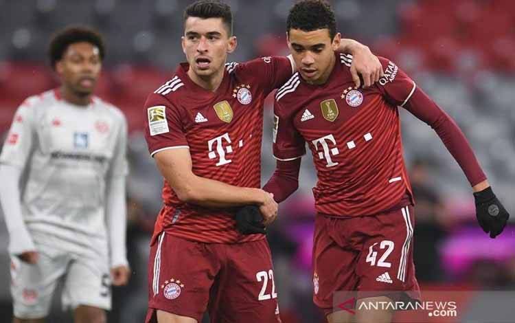 Talenta muda Bayern Muenchen Jamal Musiala (kanan) melakukan selebrasi bersama Marc Roca seusai mencetak gol ke gawang FSV Mainz dalam laga lanjutan Liga Jerman di Stadion Allianz Arena, Muenchen, Jerman, Sabtu (11/12/2021)