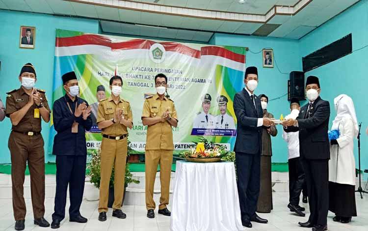 Bupati Barito Utara, Nadalsyah didampingi Wakil Bupati, Sekda, Ketua DPRD Barito Utara, dan unsur FKPD menyerahkan nasi tumpeng kepada Kepala Kantor Kementerian Agama Barito Utara usai peringatan HAB Kemenag ke 76 tahun 2022 di aula MTsN Muara Teweh, Senin 3 Januari 2022