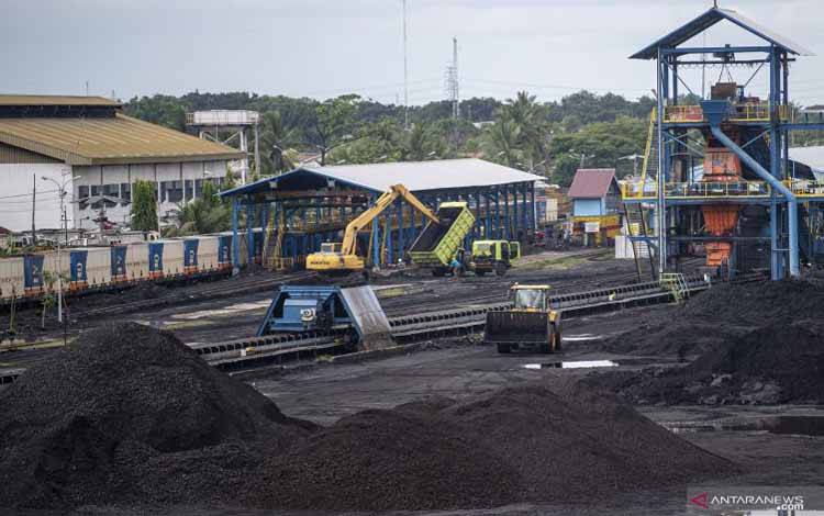 Alat berat merapikan tumpukan batu bara di area pengumpulan Dermaga Batu bara Kertapati milik PT Bukit Asam Tbk di Palembang, Sumatera Selatan, Selasa (4/1/2022)