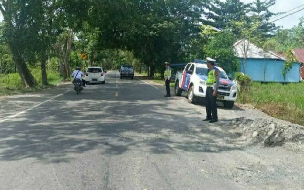 Personel Satlantas Polres Kapuas saat berjaga di daerah rawan laka, Jalan Trans Kalimantan, Minggu, 20 Februari 2022.