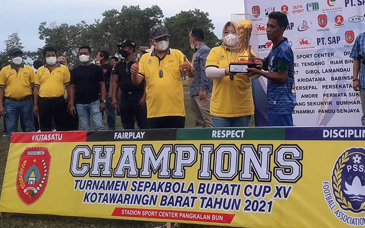 Bupati Kobar Nurhidayah menyerahkan Piala Bergilir Bupati Cup kepada pemain Persepan.
