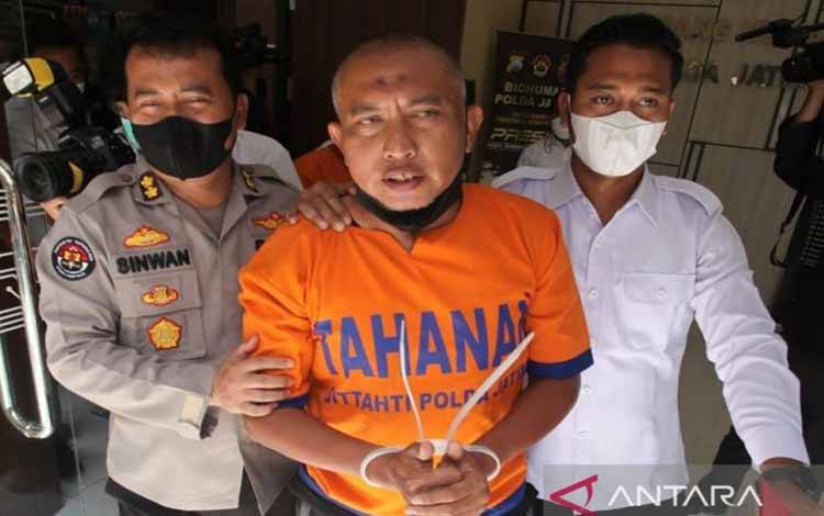 Tersangka pengaturan skor dan suap Liga 3 Zona Jatim, Bambang Suryo digelandang polisi usai dirilis di Mapolda setempat, Rabu (16/3/2022)