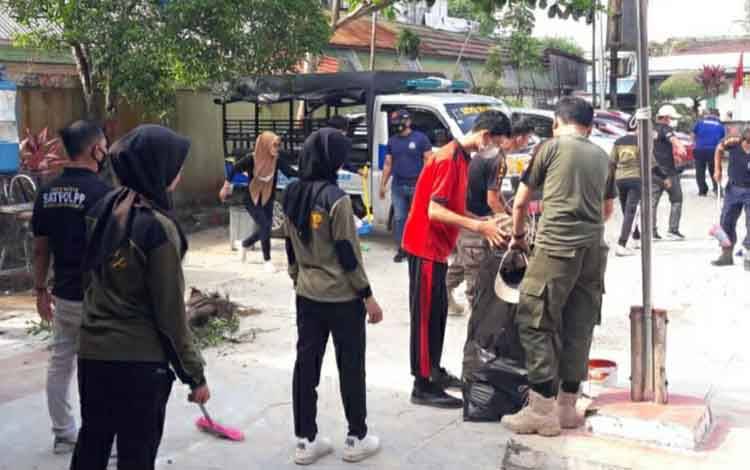 Personel Satpol PP dan Damkar Kapuas saat kerja bakti di lingkungan kantor Jalan A Yani, Jumat 1 April 2022