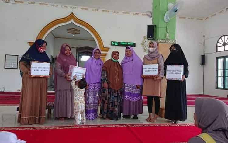Fitriani (kanan) dan peserta Sekolah Ramadan Salimah lainnya saat menerima bingkisan dari panitia