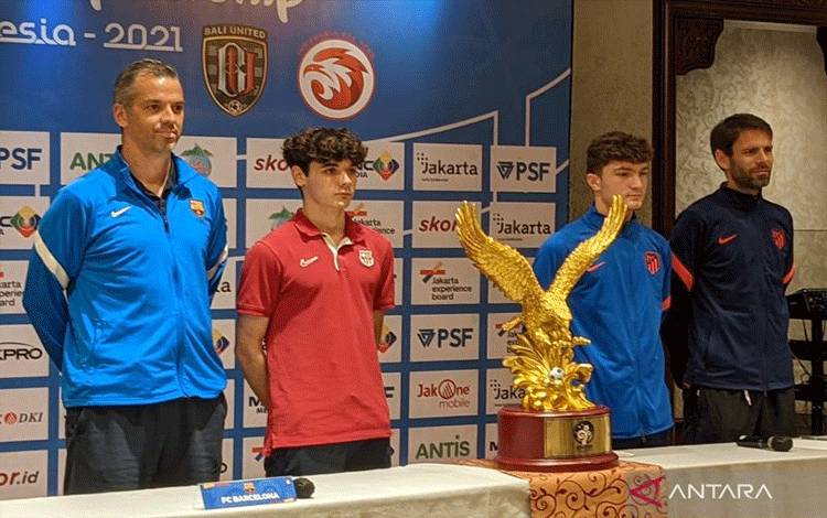 Pelatih U-18 Barcelona Iban Cuadrado (kiri) dan pelatih U-18 Atletico Madrid Daniel Perez (kanan) berfoto bersama para pemain dan trofi International Youth Championship (IYC) 2021 di Jakarta, Senin (18/4/2022). Barcelona dan Atletico Madrid akan berhadapan di partai final IYC 2021 pada Selasa (19/4) di Stadion Internasional Jakarta (JIS). (ANTARA/Michael Siahaan)