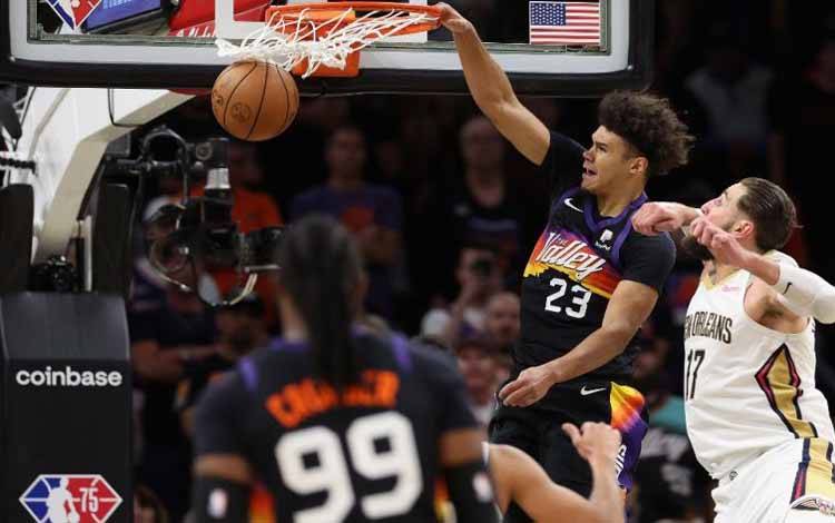 Pemain Phoenix Suns Cameron Johnson (23) melakukan dunk melewati hadangan pemain New Orleans Pelicans Jonas Valanciunas (17) dalam gim kelima putaran pertama playoff Wilayah Barat di Footprint Center, Phoenix, Arizona, Selasa 26 April 2022