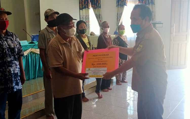 Penyaluran BLT DD tahap II untuk pembayaran Bulan April kepada KPM di Desa Teluk Lawah Kecamatan Tewah Kabupaten Gunung Mas