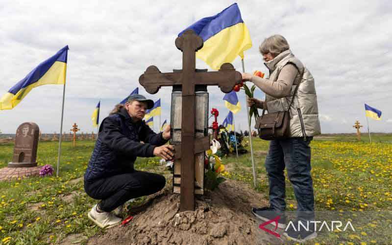 Sejumlah wanita Ukraina mengunjungi makam tentara kerabat mereka saat mengunjungi makan untuk menghormati kematian mereka di hari Minggu pertama setelah Paskah ditengah serangan Rusia terhadap Ukraina, di Dnipro, Ukraina, Minggu (1/5/2022). (foto : REUTERS/Jorge Silva/HP)