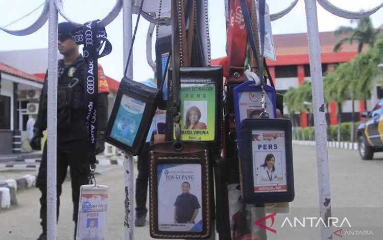 Sejumlah kartu pers digantung pagar pintu masuk halaman Polda NTT saat unjuk rasa damai di depan kantor Polda NTT di Kupang, NTT, Rabu (27/4/2022)