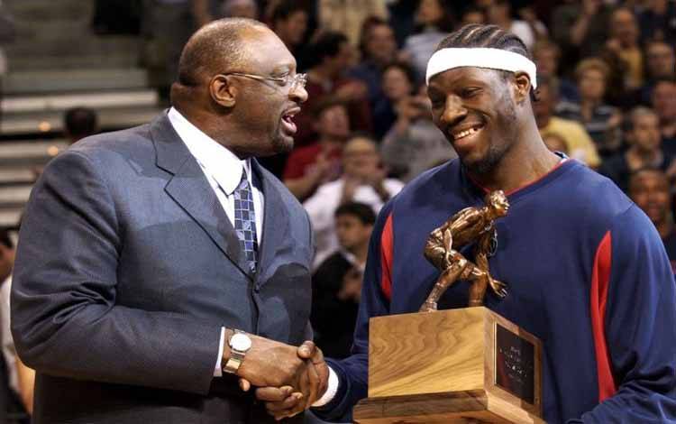 Pembesar Detroit Piston Ben Wallace menyalami NBA Hall of Famer Bob Lanier setelah dinobatkan sebagai NBA Defensive Player of the Year sebelum pertandingan perempatfinal Wilayah Timur melawan Orlando Magic di Palace of Auburn Hills, Michigan pada 23 April 2003