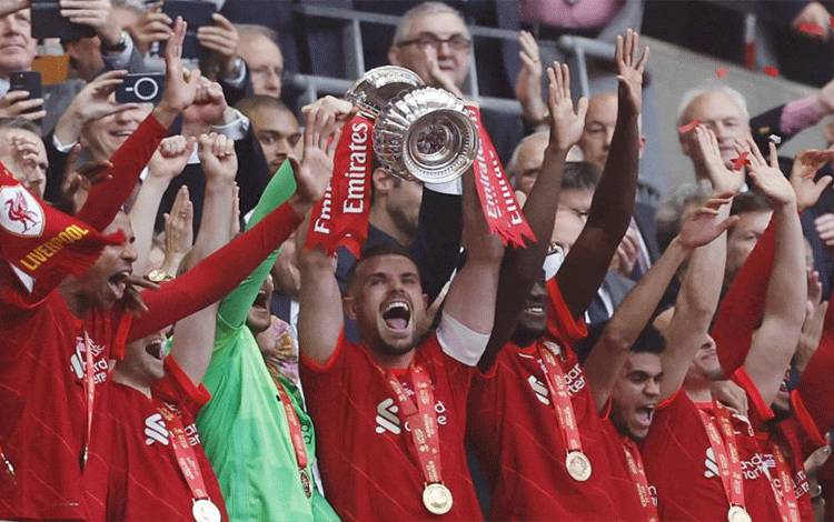 Kapten tim Liverpool Jordan Henderson mengangkat trofi PialA FA setelah memenangkan final kompetisi ini melawan Chelsea dengan adu penalti di Stadion Wembley, London, Inggris, 14 Mei 2022. (Action Images via Reuters/PETER CZIBORRA)