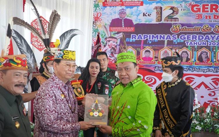 Pemberian Plakat kepada Presiden Majelis Adat Dayak Nasional, Marthin Billa.
