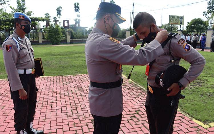 Kapolres Kapuas AKBP Qori Wicaksono saat memasang tanda peserta latihan kerja siswa Diktuk Bintara Polri di Polres Kapuas pada Kamis, 2 Juni 2022.