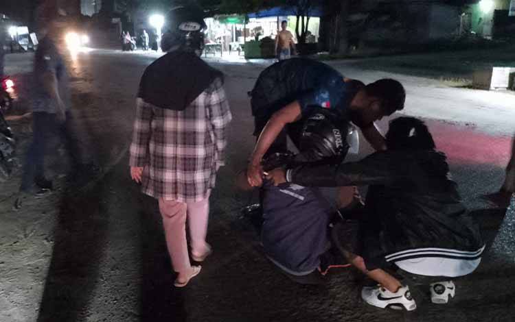 Sejumlah warga saat melakukan pertolongan pada pengendara motor yang terjatuh akibat jalanan licin di Jalan Rambutan, Kelurahan Sidorejo.