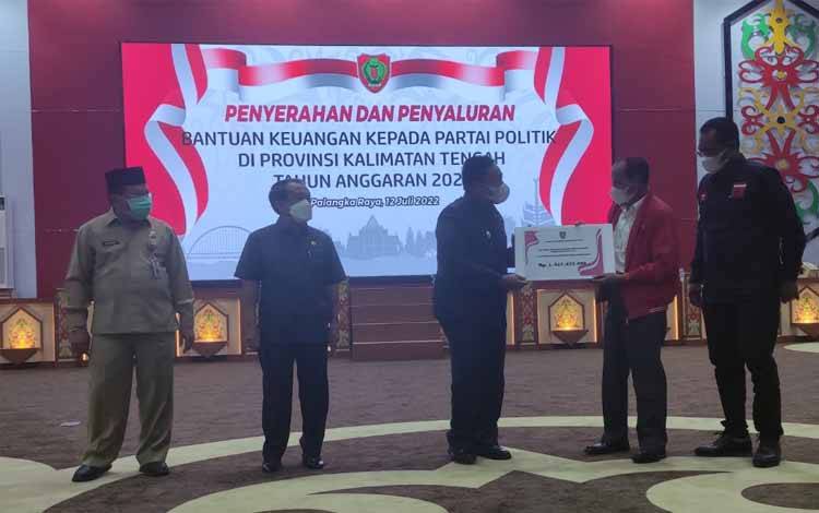 Wagub Kalteng, Edy Pratowo menyerahkan bantuan partai politik secara simbolis di Aula Jayang Tingang, Selasa 12 Juli 2022. (FOTO: HERMAWAN)