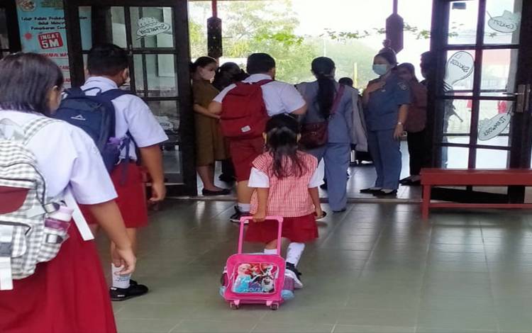 Siswa di salah satu Sekolah Dasar di Palangka Raya mengantre dengan tertib dan rapi saat memasuki bangunan sekolah untuk memulai aktivitas di sekolah, Selasa, 19 Juli 2022. (FOTO: TESTI PRISCILLA)