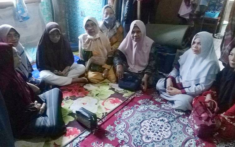 Ibu-ibu pengajian di Jalan Pelatuk menyerahkan bantuan kepada Jentawati. (FOTO: ROKIM)