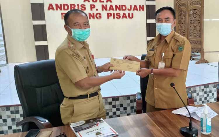 Inspektur Provinsi Kalteng Saring menyerahkan surat tugas pengawasan kepada Asisten III Kabupaten Pulang Pisau Awun S. Ampung di Aula Andris Nandjan Badan Pendapatan, Pengelolaan Keuangan dan Aset Daerah (BPPKAD) Kabupaten Pulang Pisau, Senin 25 Juli 2022. (FOTO: MMC KALTENG/DAVID)