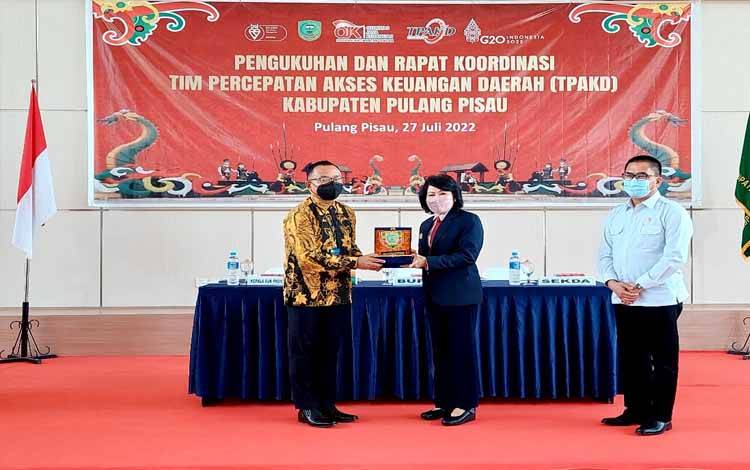 OJK Kalteng dan Pemkab Pulang Pisau bertukar cinderamata usai pengukuhan TPAKD akhir Juli 2022. (FOTO: TESTI PRISCILLA)