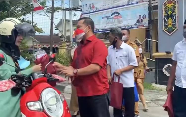 Wakil Ketua I DPRD Kapuas Yohanes saat membagikan bendera kepada masyarakat pada Selasa, 9 Agustus 2022. (FOTO: SETWAN KAPUAS)