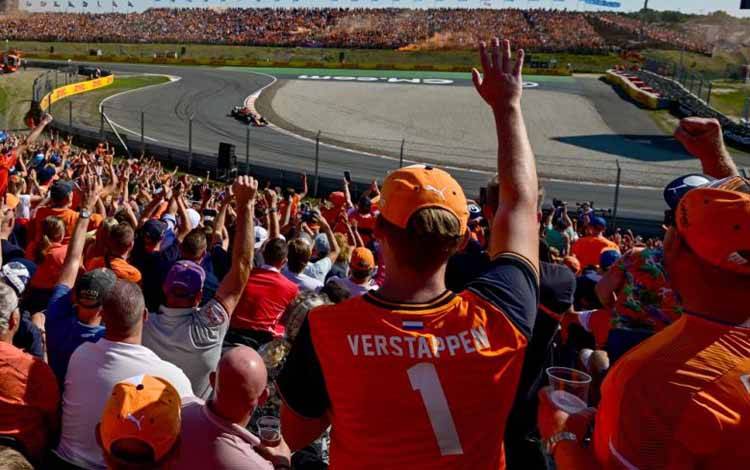 Penonton bereaksi ketika pebalap Red Bull Max Verstappen melintas di sesi kualifikasi Grand Prix Belanda, Sirkuit Zandvoort. (3/9/2022) (ANTARA/AFP/ANDREJ ISAKOVIC)